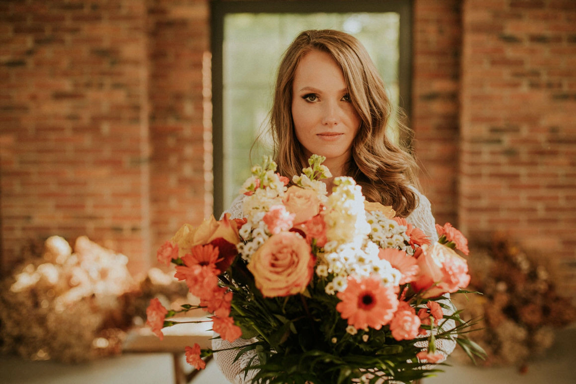 Kobieta z bukietem kolorowych kwiatów przed sobą