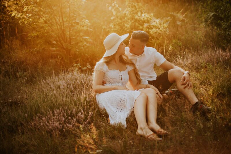 Para siedzi w słońcu na łące