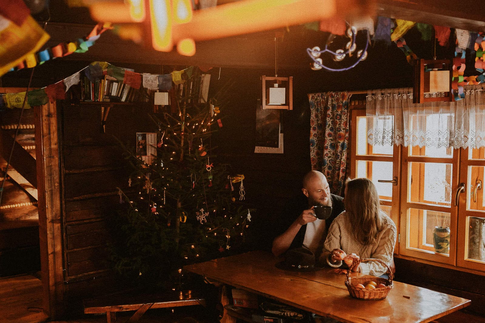 Para przy świątecznym stole w drewnianej chacie.