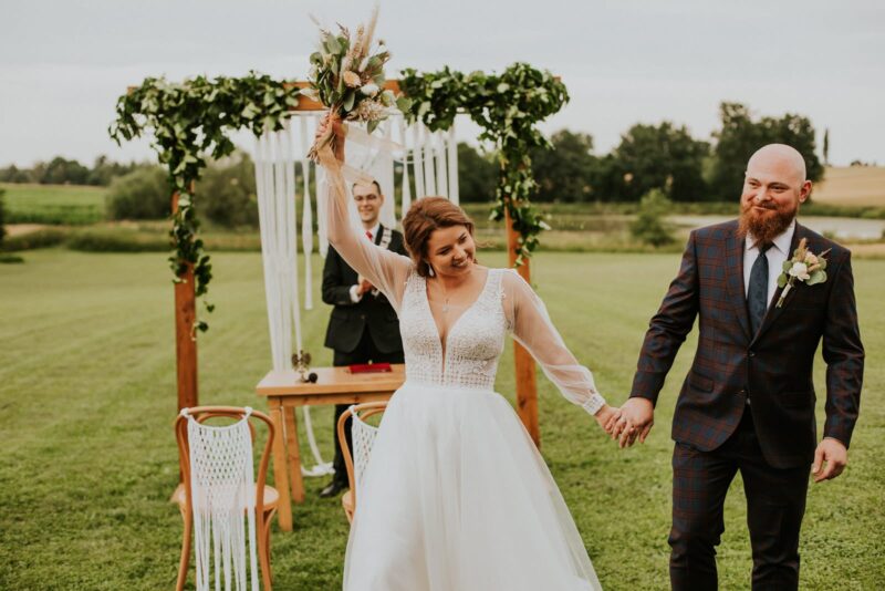 Para młoda na ślubie plenerowym cieszy się