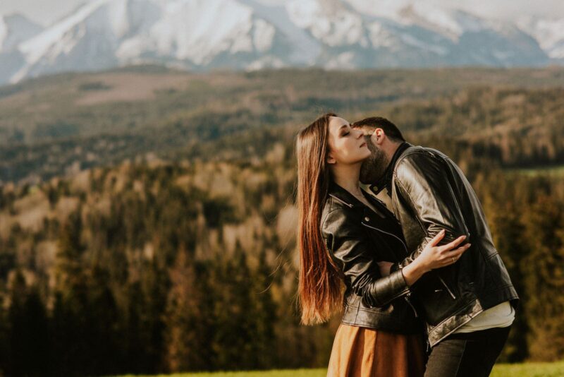 Para w kurtkach skórzanych przytula się w górach.