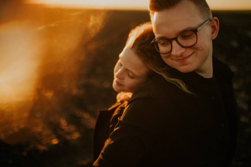 Para przytulająca się o zachodzie słońca