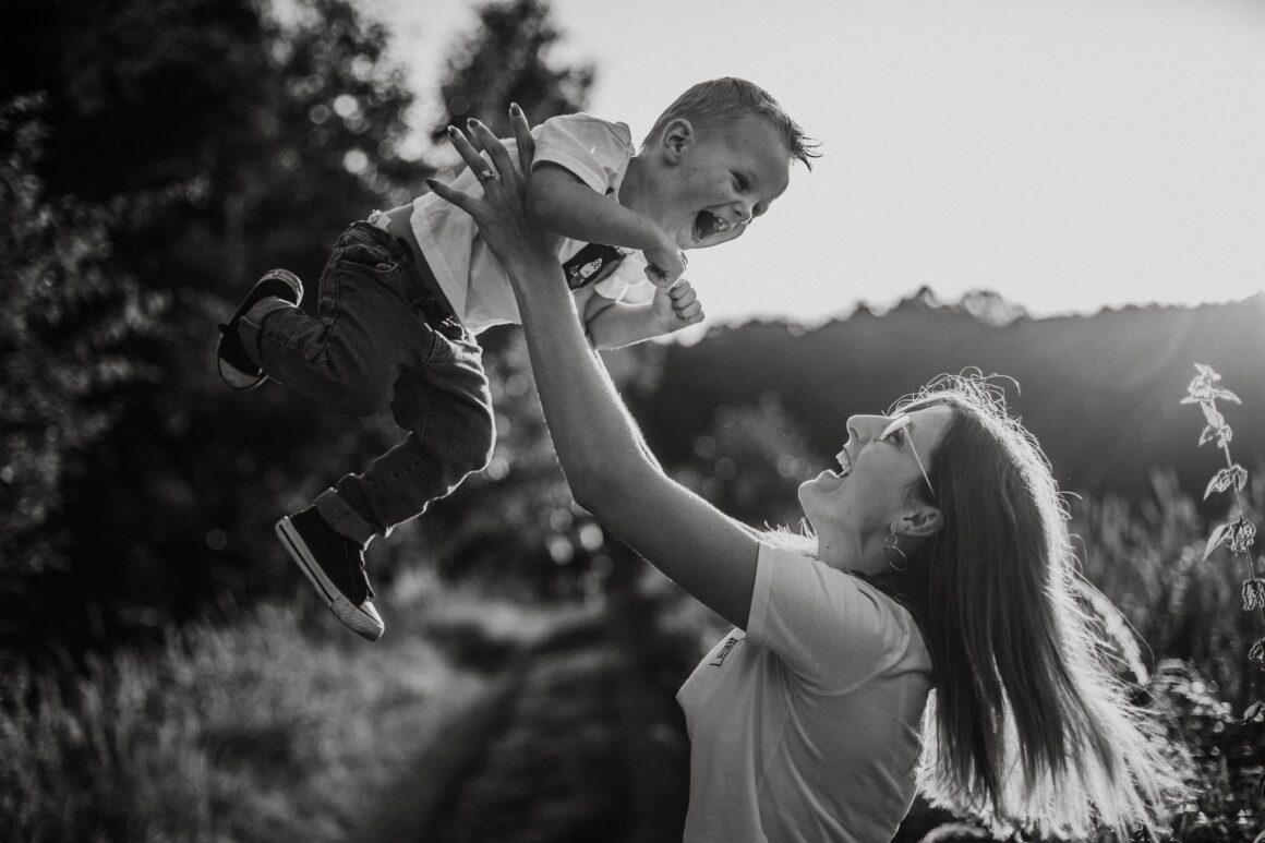 Mama bawiąca się z dzieckiem na świeżym powietrzu.