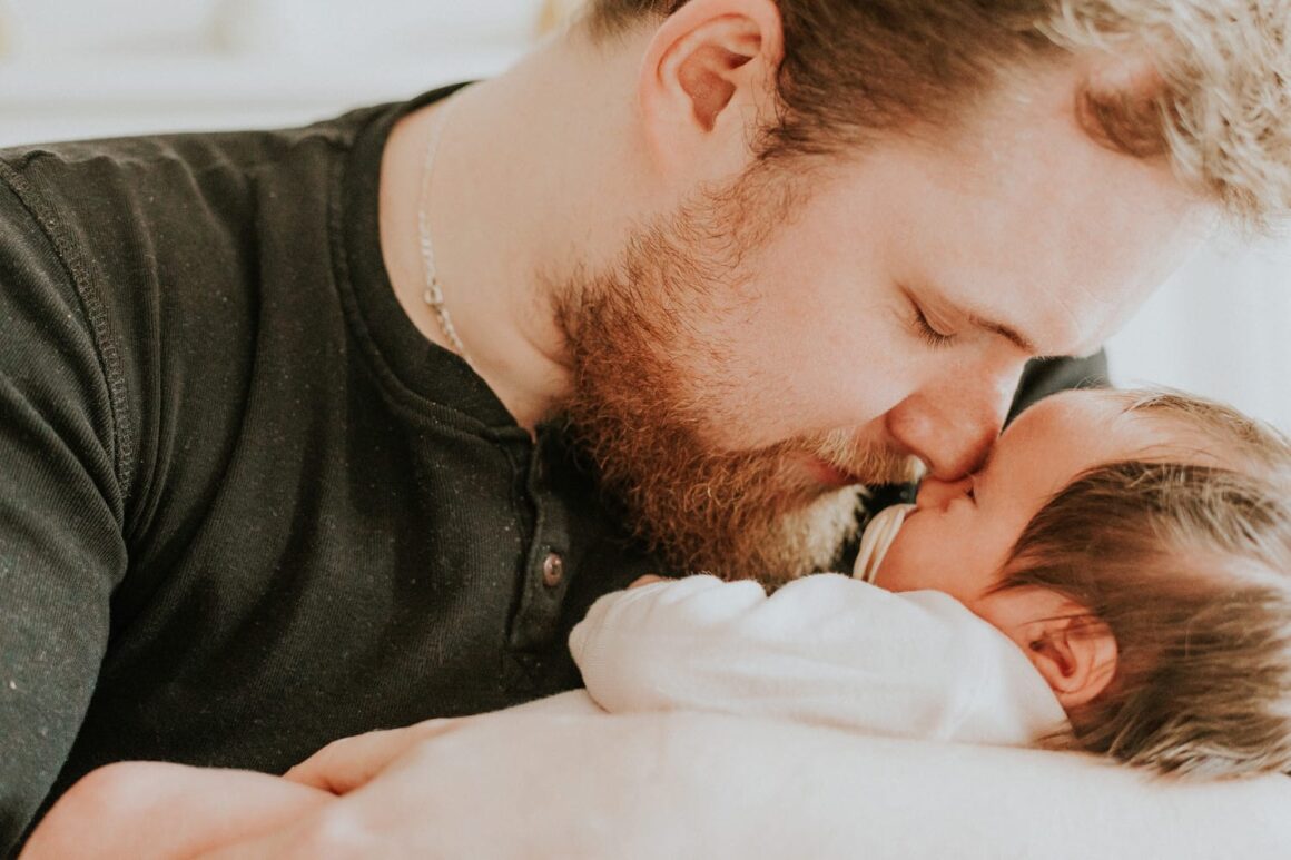 Ojciec przytula noworodka.