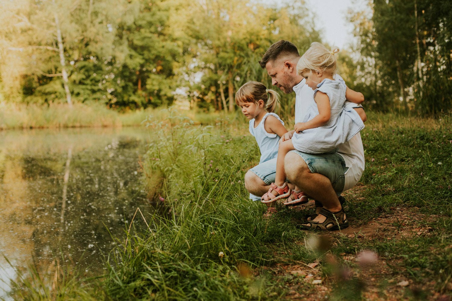 Rodzina z dziećmi nad stawem w parku.