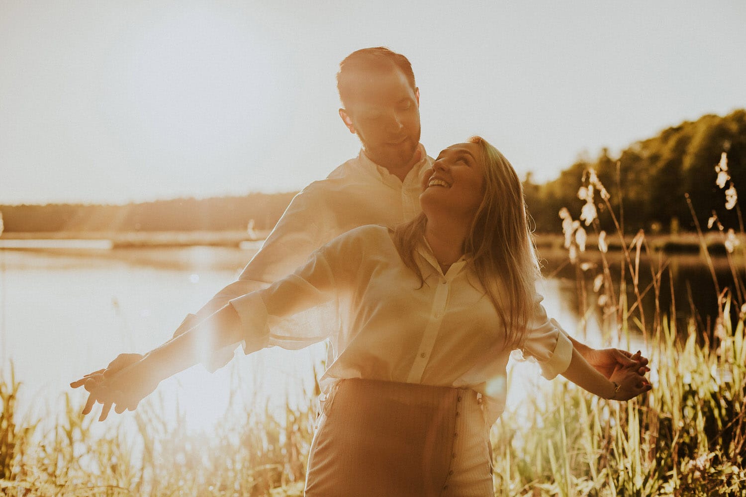 Para w zachodzącym słońcu nad jeziorem