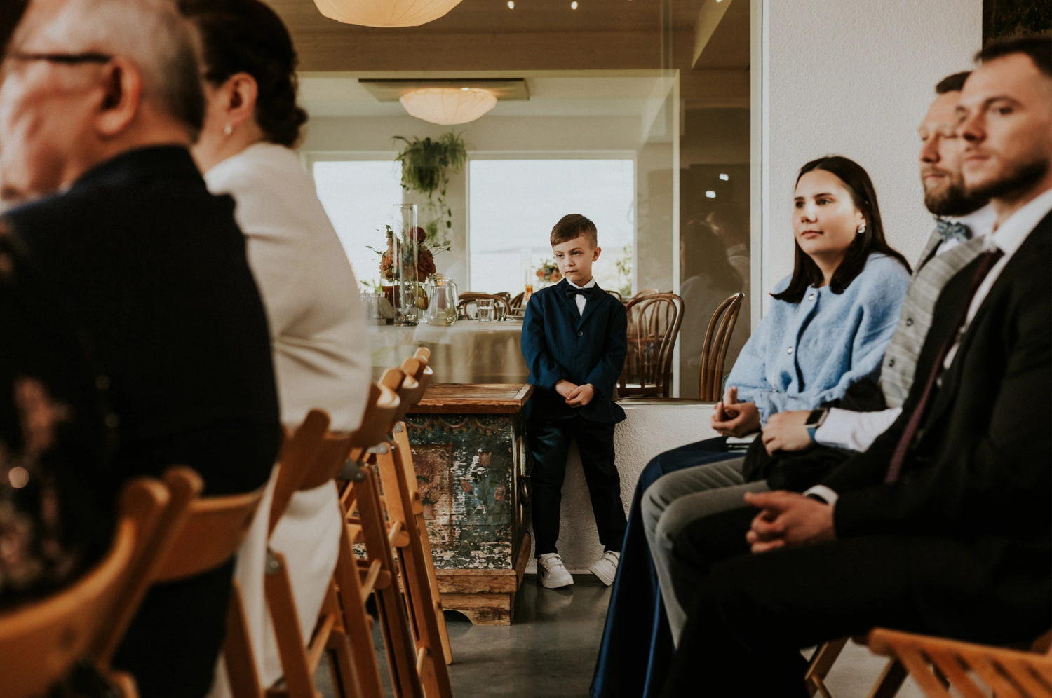 Chłopiec w garniturze przy stole w trakcie wydarzenia.