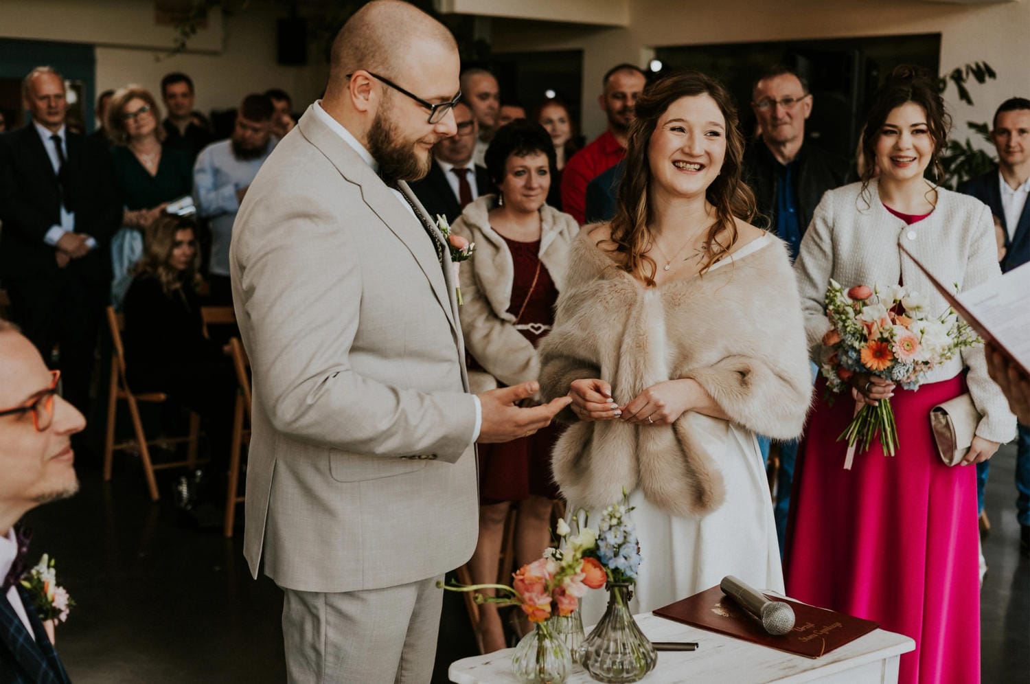 Para młoda podczas ceremonii ślubnej z gośćmi