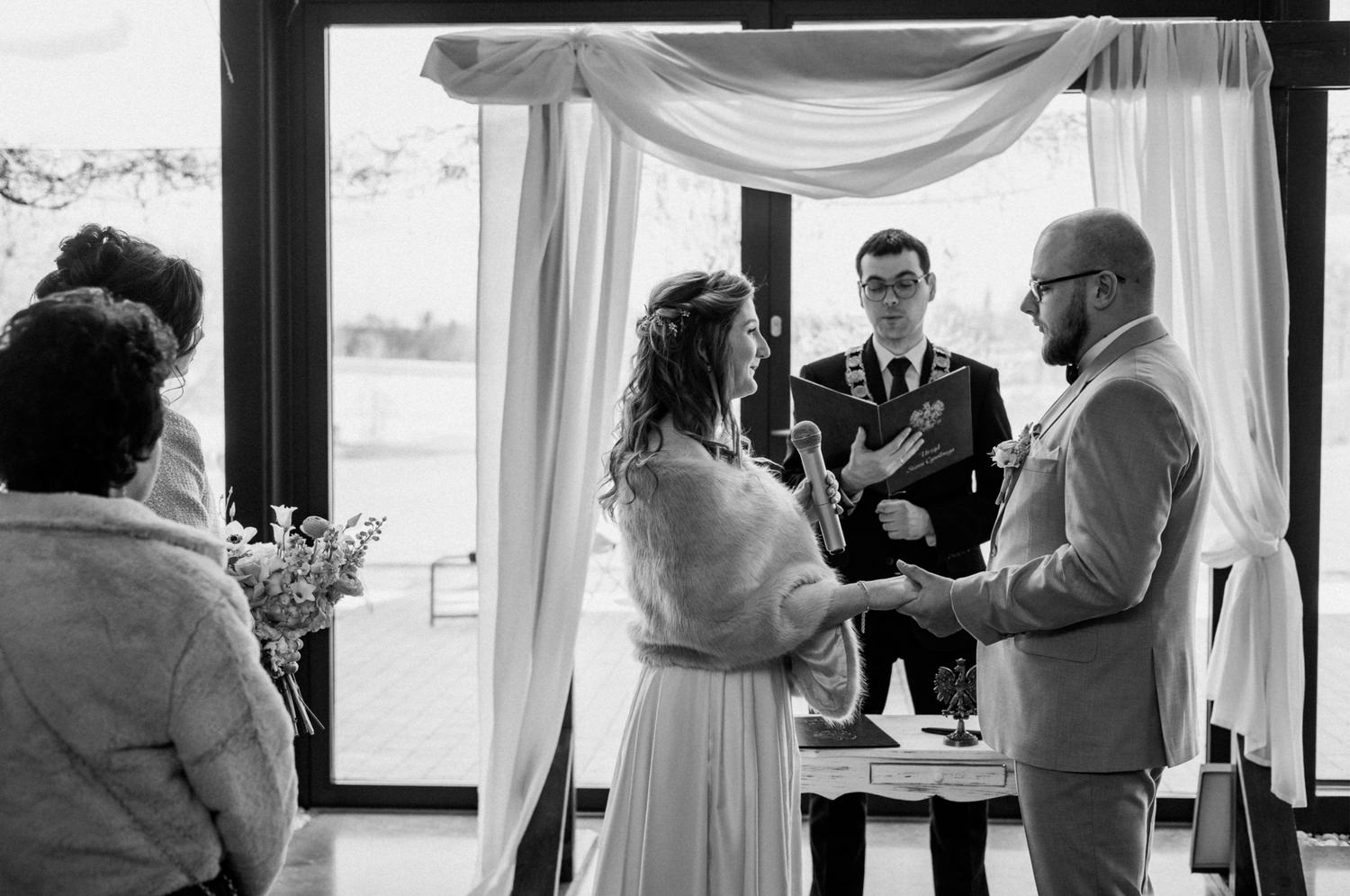 Ceremonia ślubna wewnątrz z parą młodą i urzędnikiem.