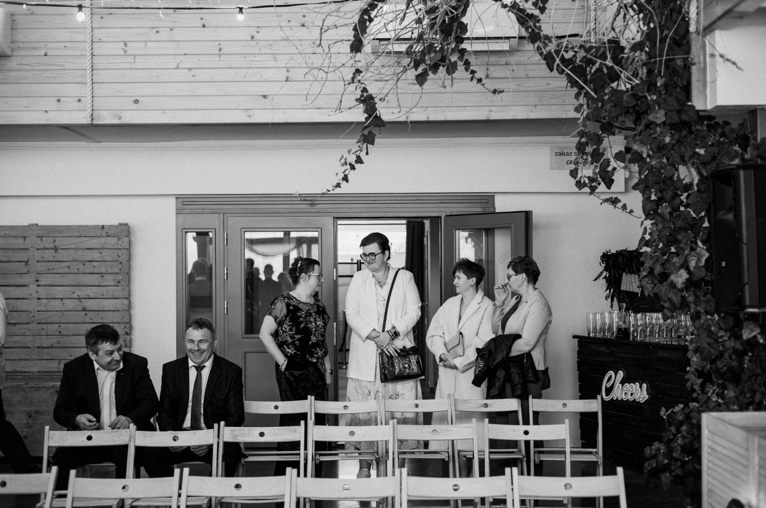 Grupa ludzi rozmawia w holu.