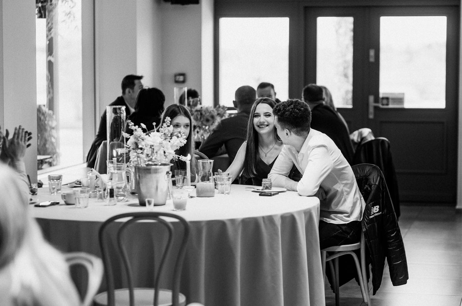 Ludzie przy stole w restauracji, rozmowa i uśmiechy.