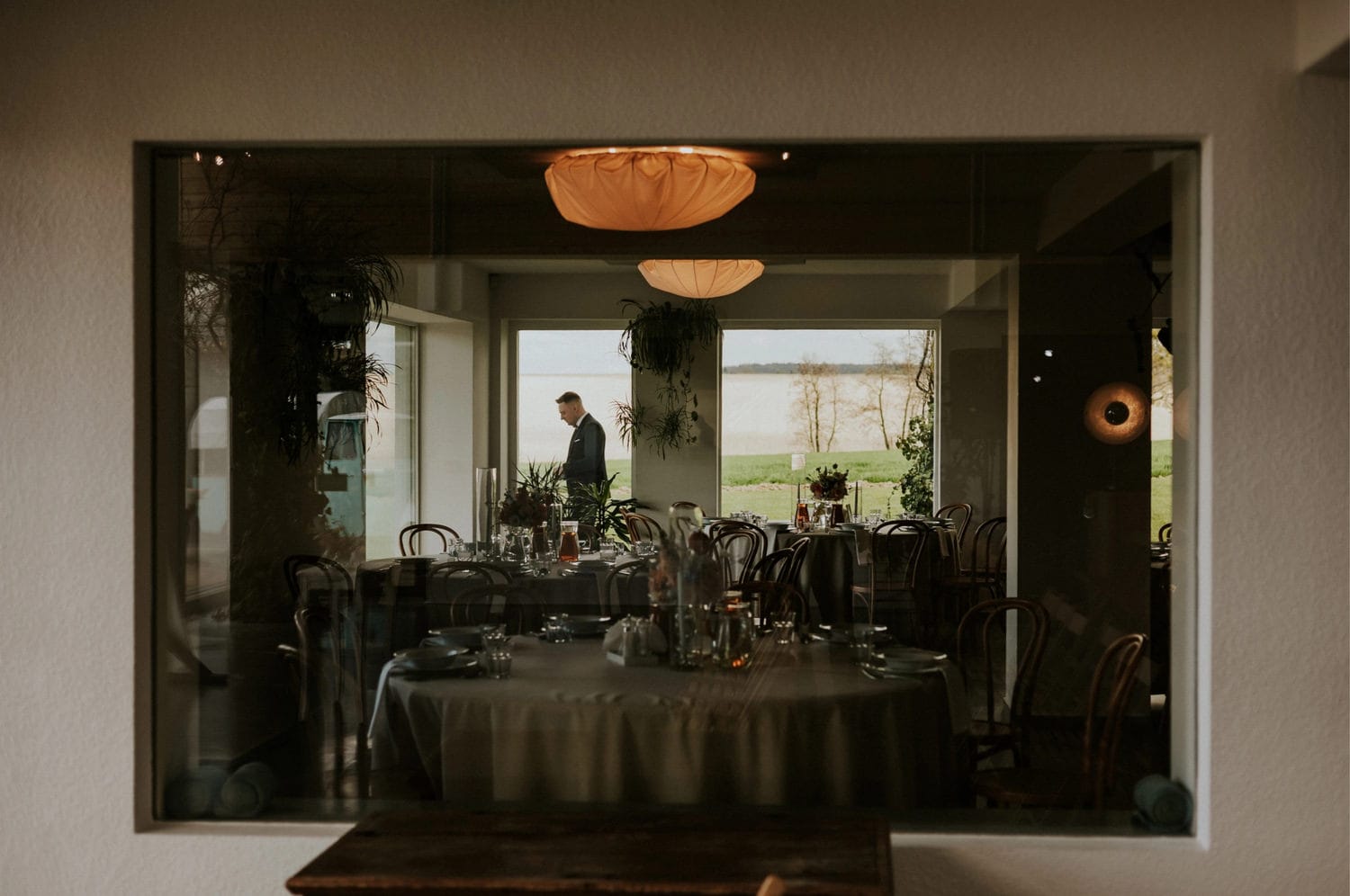 Widok z okna na elegancką restaurację z ogrodem.