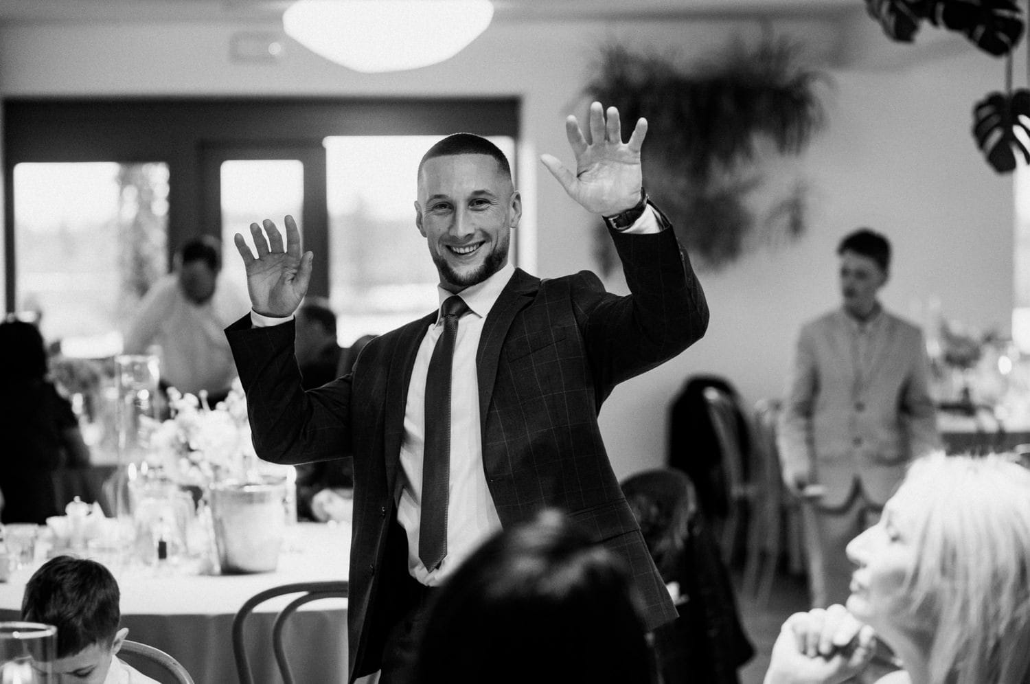 Uśmiechnięty mężczyzna w garniturze na przyjęciu.