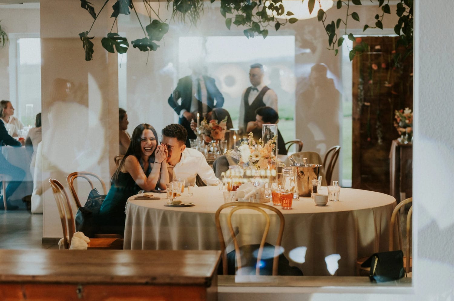 Spotkanie przy stole weselnym, uśmiechnięci goście.