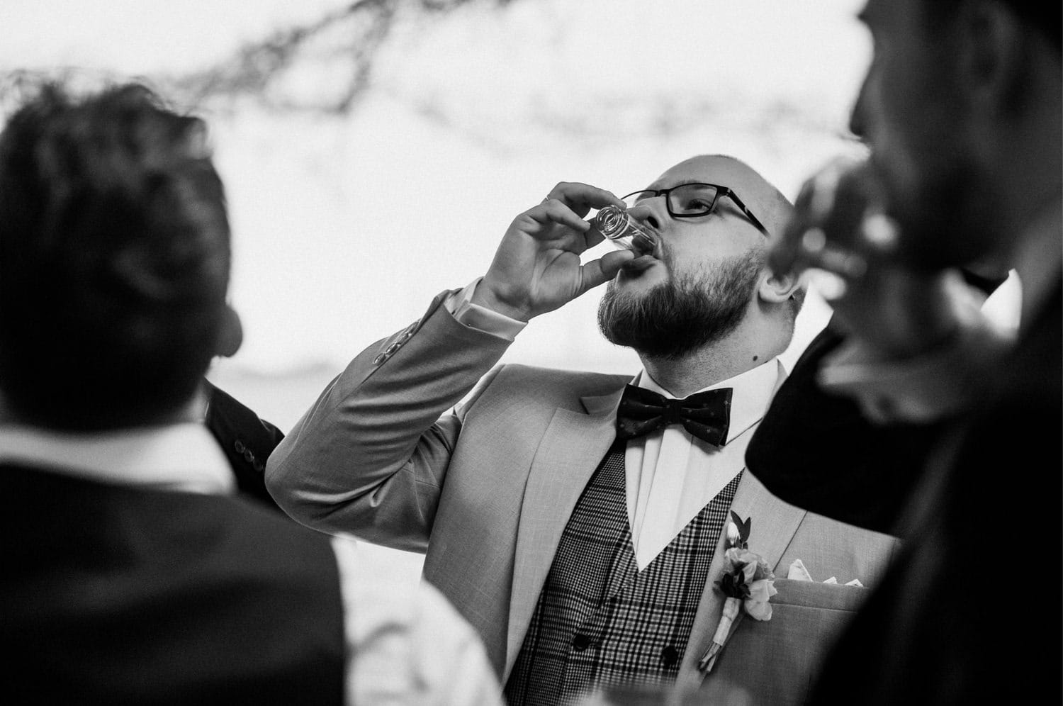 Mężczyzna pije napój w garniturze i muchą