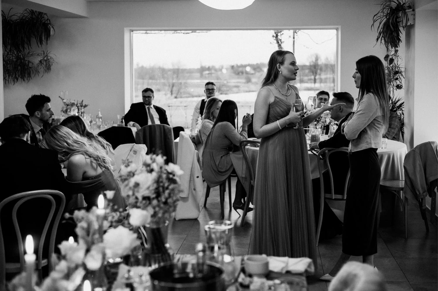 Ludzie rozmawiają przy stole na przyjęciu weselnym.