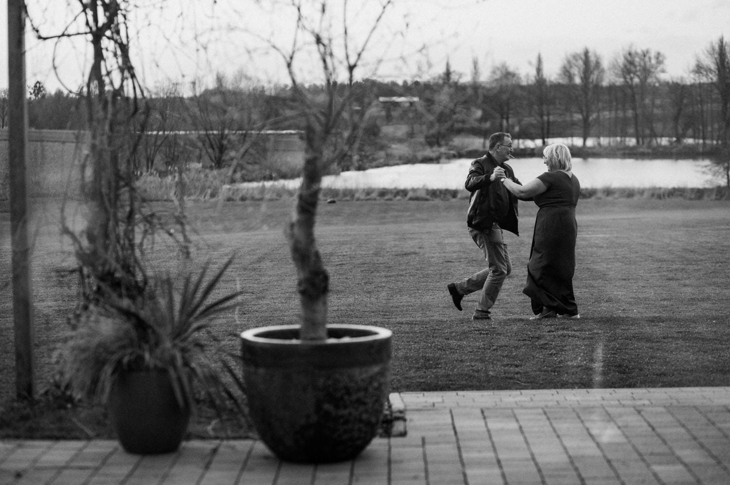 Para tańczy w ogrodzie nad jeziorem.