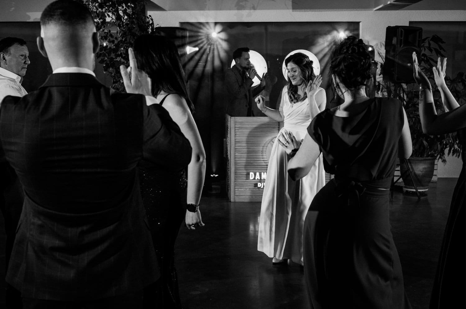 Osoby tańczące na weselu, DJ w tle.