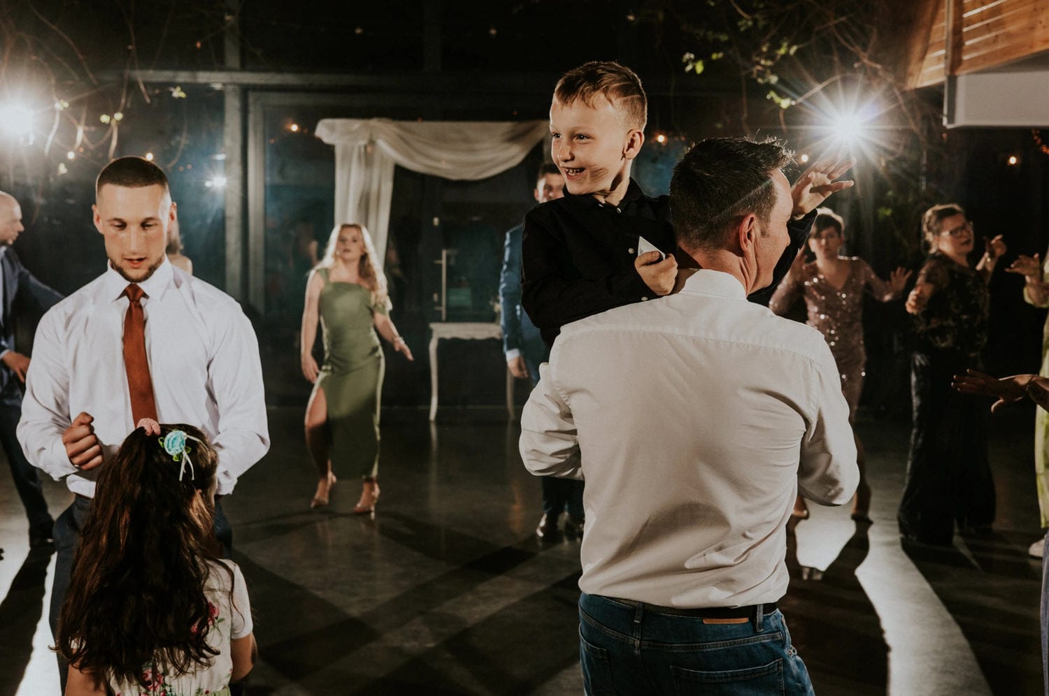 Goście tańczą na przyjęciu weselnym.