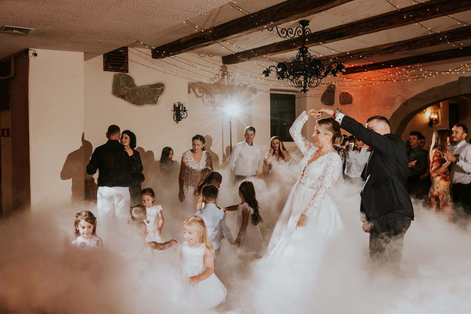 Para młoda tańczy w chmurze na weselu.