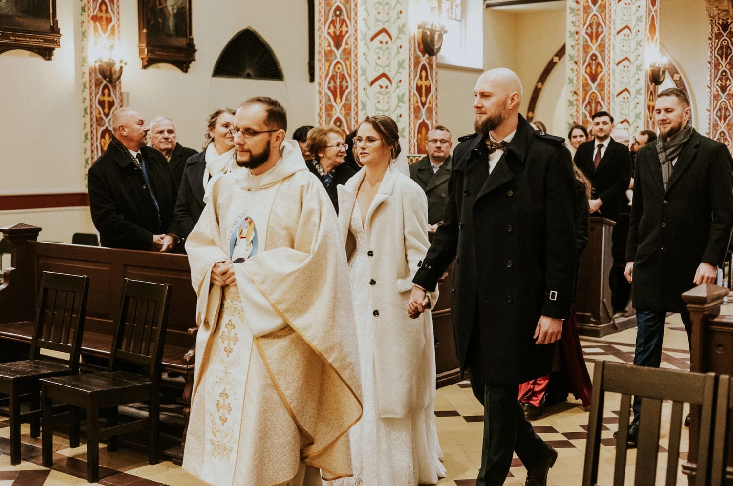 Ślub w kościele, para młoda z księdzem.