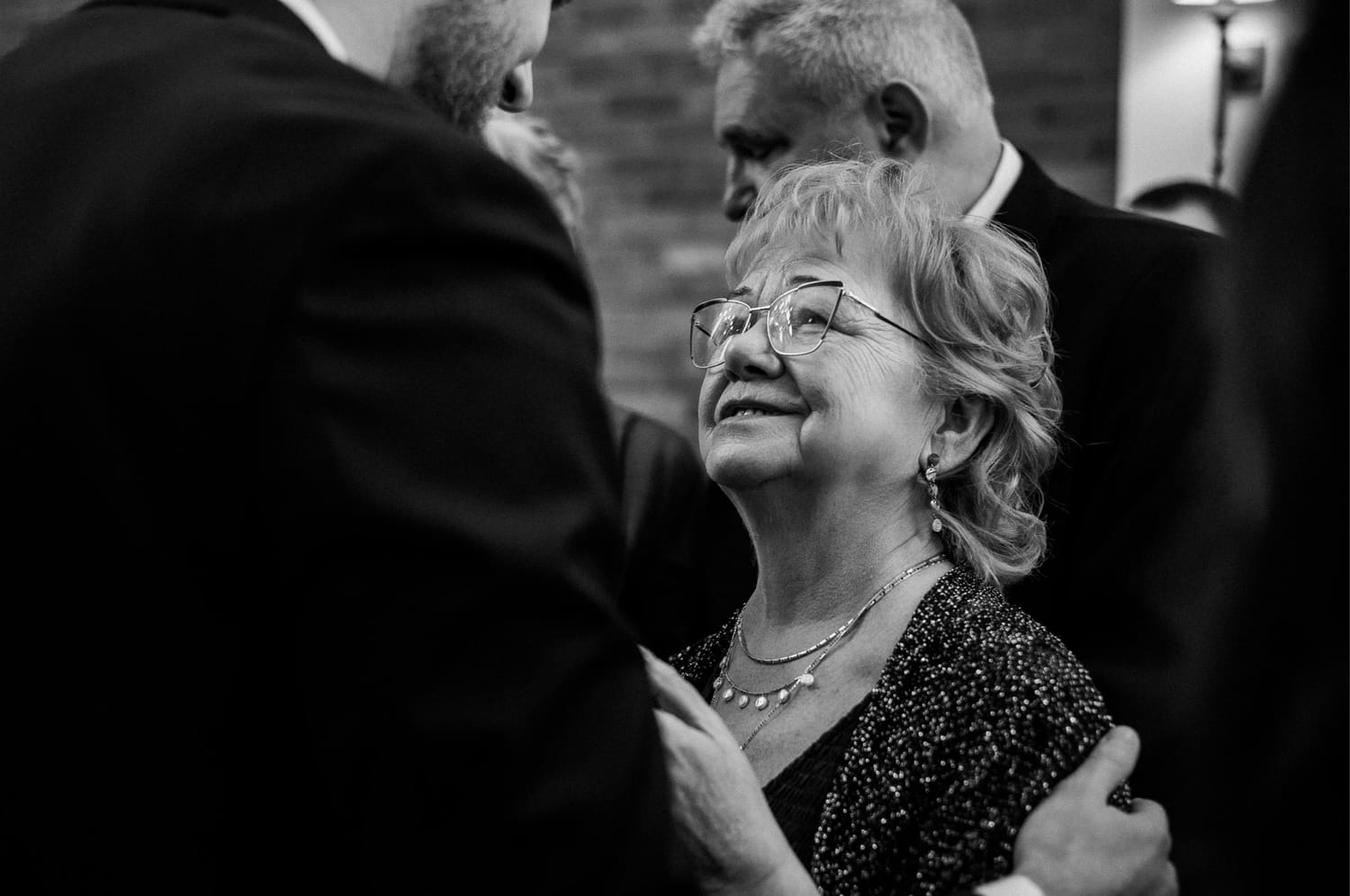 Starsza kobieta uśmiecha się do mężczyzny na przyjęciu.