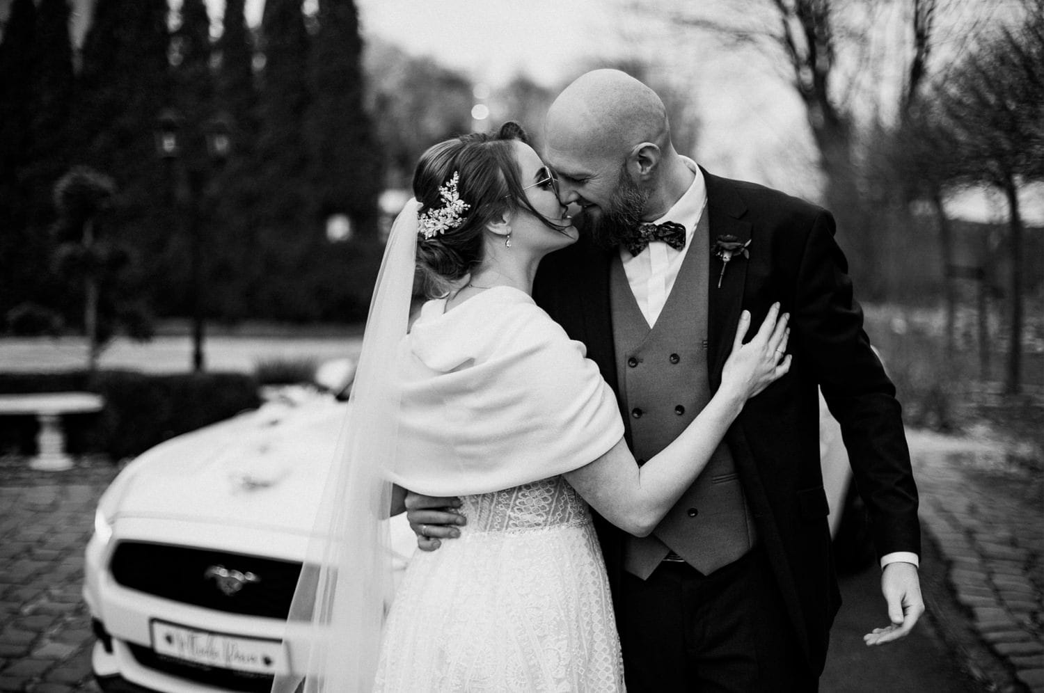 Para młoda w romantycznym pocałunku przy samochodzie.
