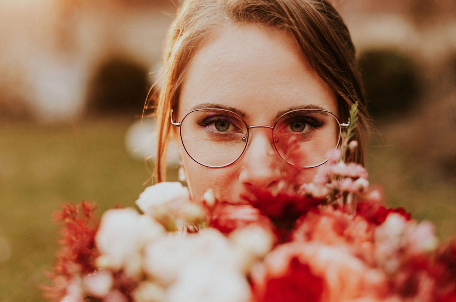 Kobieta w okularach z bukietem kwiatów