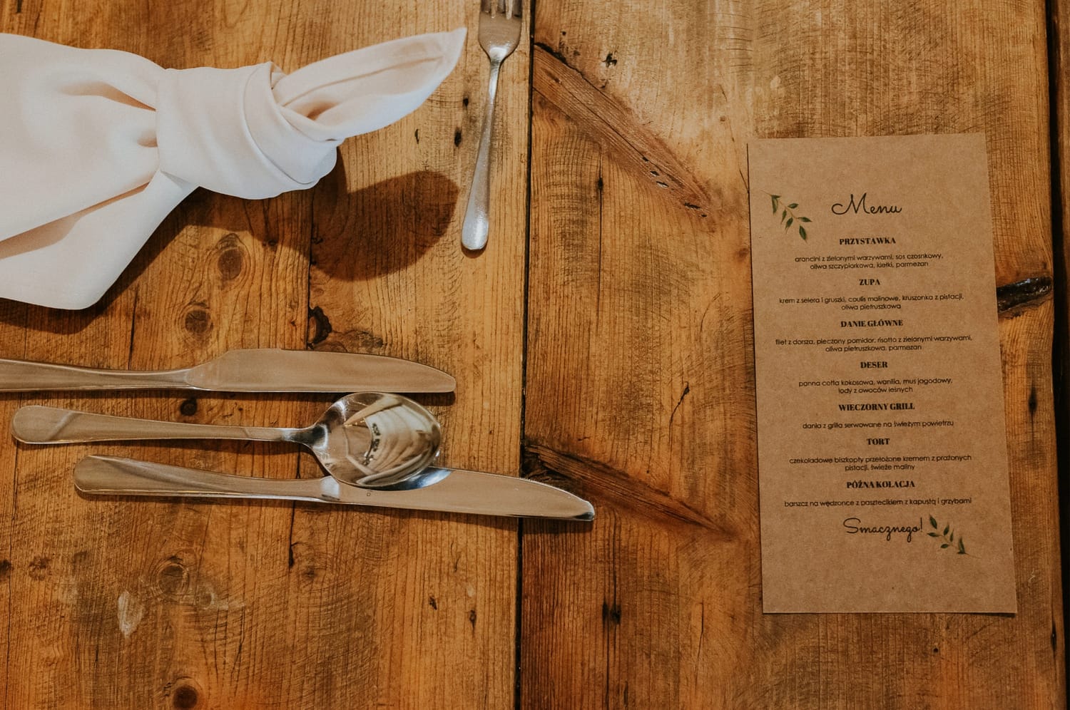 Drewniany stół z menu i sztućcami.